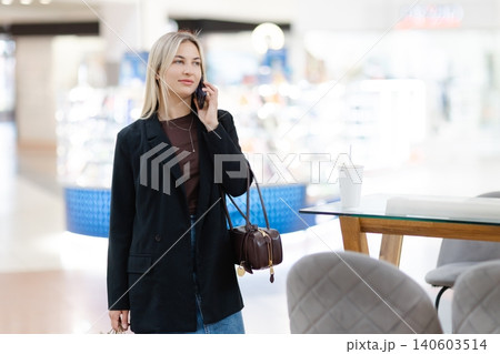 Woman talking on smartphone in shopping mall Woman talking on smartphone in shopping mall 140603514