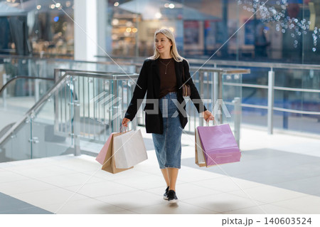 Woman enjoying shopping day carrying colorful bags Woman enjoying shopping day carrying colorful bags 140603524