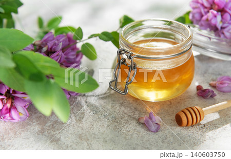 Natural acacia honey in a jar with flowers Natural acacia honey in a jar with flowers 140603750