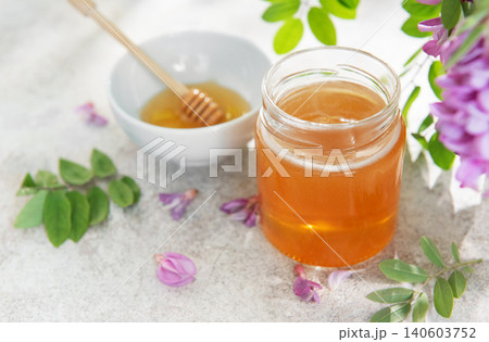 Acacia honey jar with dipper and blossoms 140603752