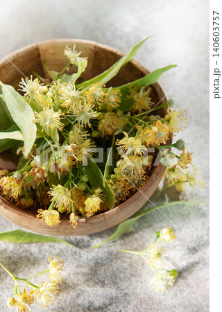 Linden flowers blooming inside wooden bowl for herbal tea Linden flowers blooming inside wooden bowl for herbal tea 140603757