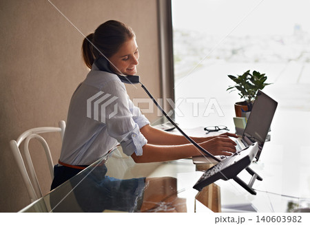 Businesswoman, laptop and talking on phone professional, formal clothes and working in office. Female person, smile and communicate with clients or consultant, communication and typing in computer 140603982