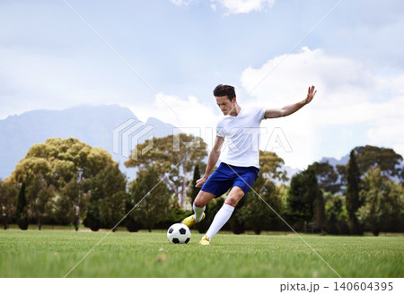 Man, soccer player and shooting with ball on field with power, speed and aim at target in training for club. Person, football and sport with kick exercise and workout for wellness, fitness and game 140604395