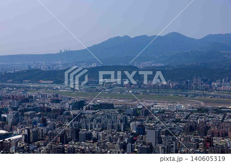 山々を背景に眼下に広がる広大な滑走路と密集する都市のビル群の風景 山々を背景に眼下に広がる広大な滑走路と密集する都市のビル群の風景 140605319