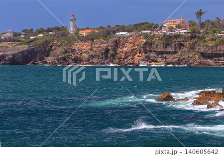 View of the rugged cliffs of Boca do Inferno and Guia Lighthouse along the Atlantic coastline near Cascais, Portugal. View of the rugged cliffs of Boca do Inferno and Guia Lighthouse along the Atlantic coastline near Cascais, Portugal. 140605642