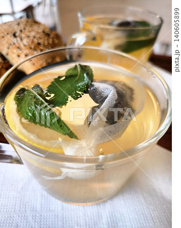 Close-up of fresh mint tea with lemon in a clear cup. Close-up of fresh mint tea with lemon in a clear cup. 140605899