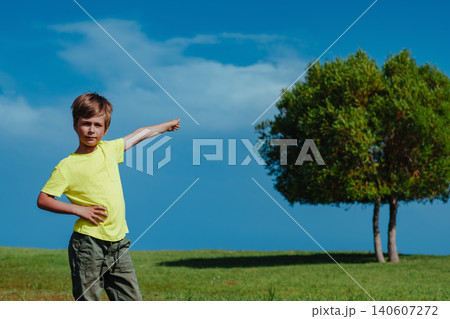 Boy points to the tree on a sunny day, ecology concept Boy points to the tree on a sunny day, ecology concept 140607272