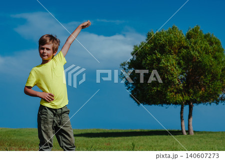 Boy showing height of the tree on a sunny day, ecology concept Boy showing height of the tree on a sunny day, ecology concept 140607273