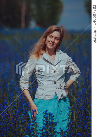 Portrait of beautiful elegant woman in a blue flower meadow Portrait of beautiful elegant woman in a blue flower meadow 140607282