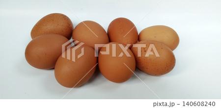 Close-up photo of several fresh brown chicken eggs arranged in a group on a white background. Close-up photo of several fresh brown chicken eggs arranged in a group on a white background. 140608240