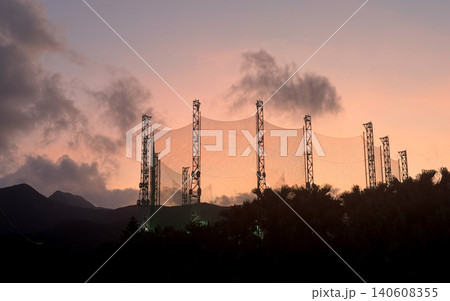Golf driving range nets silhouetted against a vibrant sunset sky 140608355
