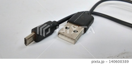Close-up photo of a black USB charging cable with USB Type-A and Micro USB connectors placed on a clean white background. Close-up photo of a black USB charging cable with USB Type-A and Micro USB connectors placed on a clean white background. 140608389