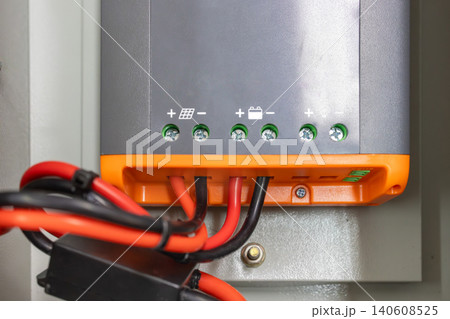 Technician connect solar and battery cable on charger controller for off-grid solar system. 140608525
