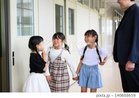 学校の廊下に並んで笑顔で立つ男性教師と女子小学生たち 学校の廊下に並んで笑顔で立つ男性教師と女子小学生たち 140608659