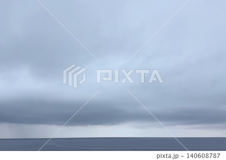 霞んだ曇り空と薄雲が広がる静かな海 霞んだ曇り空と薄雲が広がる静かな海 140608787