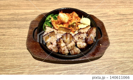 鉄鍋に盛り付けられた韓国風焼肉のサムギョプサル 鉄鍋に盛り付けられた韓国風焼肉のサムギョプサル 140611066