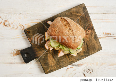 Sandwich with chicken, cucumber and creamy mushroom sauce on cutting board Sandwich with chicken, cucumber and creamy mushroom sauce on cutting board 140611332