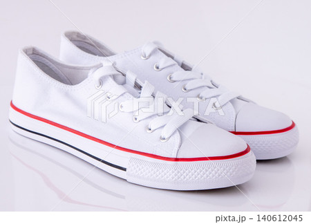 Pair of White Canvas Sneakers background Pair of White Canvas Sneakers background 140612045