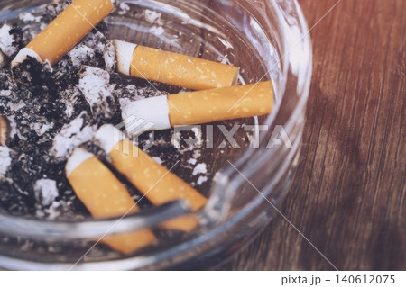 Ashtray with cigarette butts and ashes in a close-up shot Ashtray with cigarette butts and ashes in a close-up shot 140612075