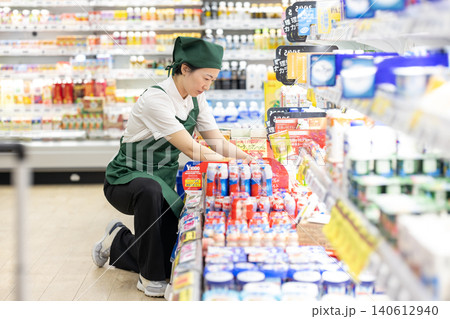 食品売り場で品出しをする女性スタッフ 140612940