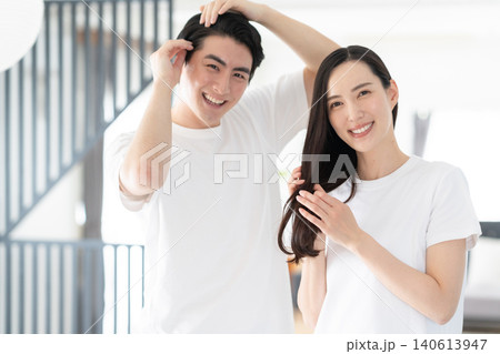 リビングでヘアケアをするミドルの夫婦 リビングでヘアケアをするミドルの夫婦 140613947