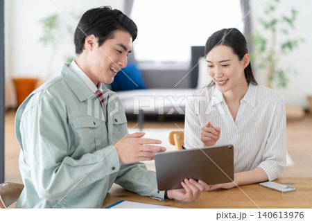 リフォームの打ち合わせをする作業員と主婦 リフォームの打ち合わせをする作業員と主婦 140613976