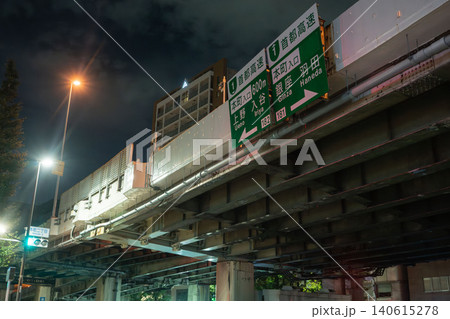 夜空にそびえる首都高速道路の高架橋と、銀座・羽田方面を示す緑の案内標識 夜空にそびえる首都高速道路の高架橋と、銀座・羽田方面を示す緑の案内標識 140615278