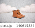 A cute pair of children's leather boots on a soft blanket 140615824