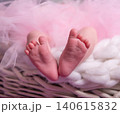 Tiny feet of a newborn baby in pink tulle and plaid. 140615832