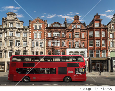 Red Double Decker Bus on London Street With Historic Brick Architecture and Blue Sky Red Double Decker Bus on London Street With Historic Brick Architecture and Blue Sky 140618299