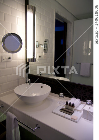 Fujairah, United Arab Emirates, November 04 2017: Bathroom vanity with white tiles and large mirror in luxury hotel Fujairah, United Arab Emirates, November 04 2017: Bathroom vanity with white tiles and large mirror in luxury hotel 140618606