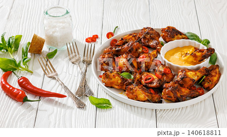 Char-grilled chicken wings on a plate with sauce 140618811