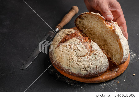 Fresh artisan sourdough bread sliced by hand on dark background, rustic homemade bakery concept 140619906