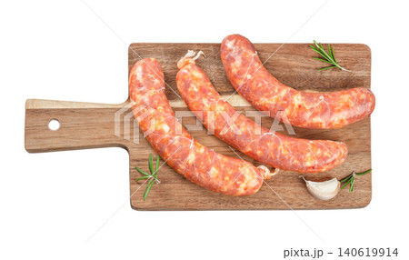 Raw spicy sausages on wooden cutting board isolated top view rustic butcher meat preparation concept 140619914
