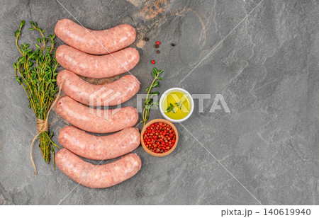 Raw sausages with thyme olive oil and pepper on dark stone background with copy space 140619940