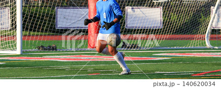 Soccer Goalkeeper Runs Toward the Ball Making a Save on the Soccer Field During a Game Soccer Goalkeeper Runs Toward the Ball Making a Save on the Soccer Field During a Game 140620034