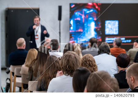 Business speaker presenting to attentive audience during conference presentation with large screen Business speaker presenting to attentive audience during conference presentation with large screen 140620793