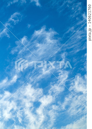 A vertical photo of a blue sky against which streams of white clouds blur, blurring at the edges. Art blank for the background A vertical photo of a blue sky against which streams of white clouds blur, blurring at the edges. Art blank for the background 140621760