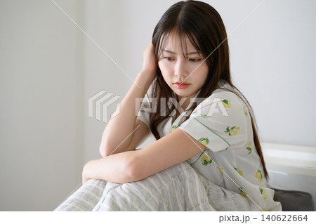 ベッドに座って髪を触る日本人女性 ベッドに座って髪を触る日本人女性 140622664