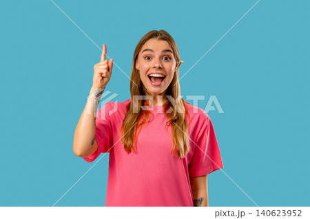 Happy woman having idea eureka moment, pointing finger up on Blue background. Clever lady showing Happy woman having idea eureka moment, pointing finger up on Blue background. Clever lady showing 140623952