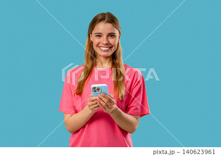 Pretty Woman Surfing Internet On Smartphone. Girl With Smile On Blue Background 140623961