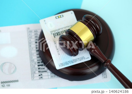 Generic driving license and judgement mallet on blue background Generic driving license and judgement mallet on blue background 140624186