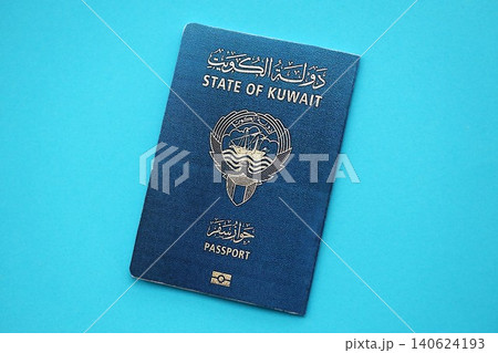 Kuwait passport book on light blue paper background close up. Travel document Kuwait passport book on light blue paper background close up. Travel document 140624193