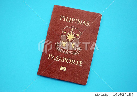 Philippines passport book on light blue paper background close up. Travel document 140624194