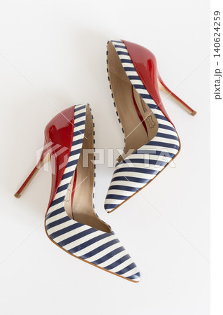 Striped navy high heel shoes with red patent details viewed from above on white Striped navy high heel shoes with red patent details viewed from above on white 140624259