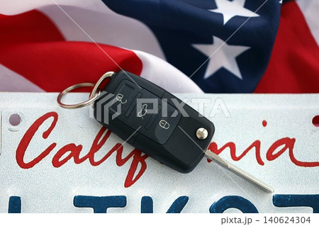 Remote control car keys on California license plate on US flag. Car driving in California Remote control car keys on California license plate on US flag. Car driving in California 140624304