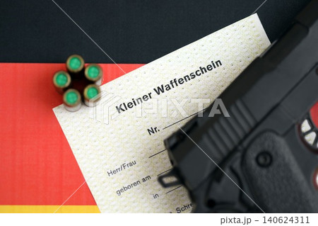 German light firearms license and handgun with bullets on Germany flag close up. Gun permit German light firearms license and handgun with bullets on Germany flag close up. Gun permit 140624311