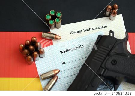 German firearms licenses and handgun with bullets on Germany flag close up. Gun permit German firearms licenses and handgun with bullets on Germany flag close up. Gun permit 140624312