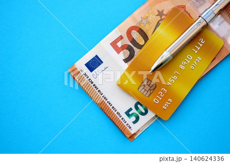 Credit card and pen with euro currency money bills banknotes on light blue background Credit card and pen with euro currency money bills banknotes on light blue background 140624336