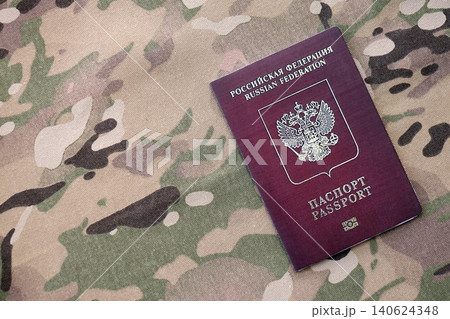 Russian passport on multicam camouflage fabric. Concept of russian army and invasion to Ukraine Russian passport on multicam camouflage fabric. Concept of russian army and invasion to Ukraine 140624348